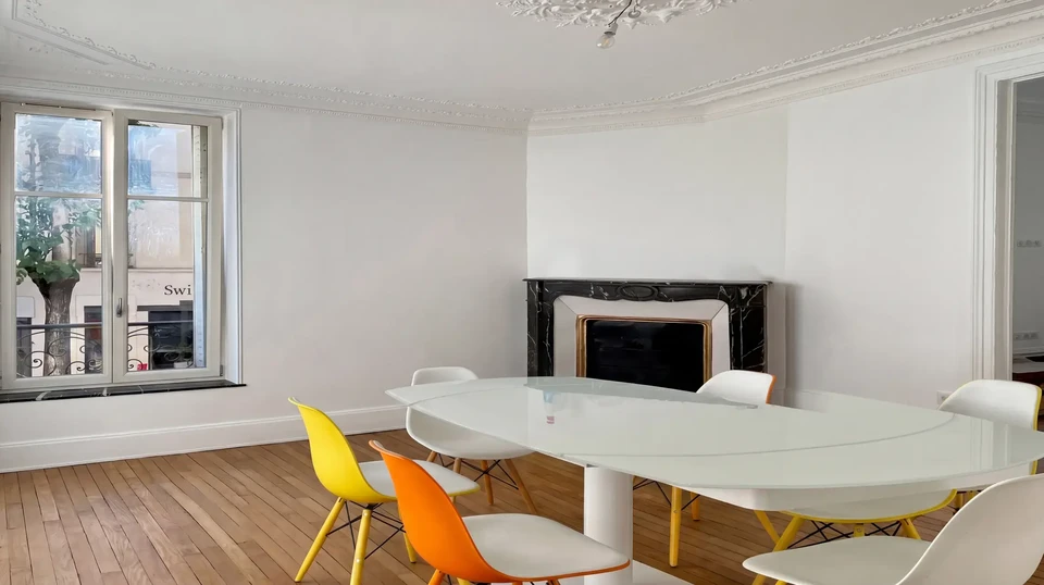 Artisan à genoux installe un parquet en lames de bois sur chantier intérieur